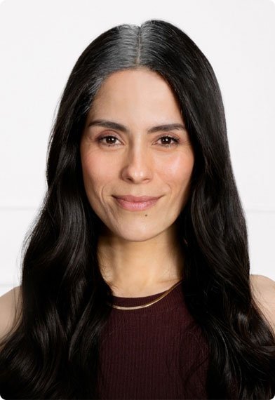 דוגמנית מציגה שיער לבן בשורשים לפני השימוש בספריי מג'יק ריטאצ'